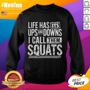 Man in a sweatshirt lifting weights at Awesome Fitness gym during a squat workout, showcasing strength and determination.