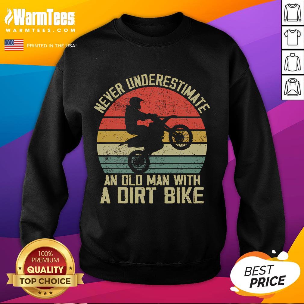 Vintage sunset sweatshirt featuring the phrase 'Never Underestimate an Old Man with a Dirt Bike' in bold design.