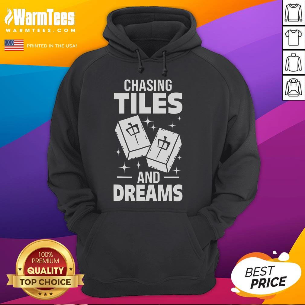Asian player wearing 'Good Mahjong Chasing Tiles and Dreams' hoodie, showcasing passion for Mahjong in a vibrant setting.