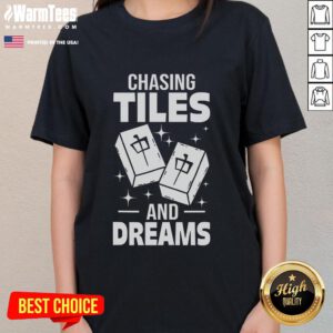 Asian player enjoying a game of Mahjong, wearing a stylish 'Chasing Tiles and Dreams' ladies tee, immersed in gameplay.