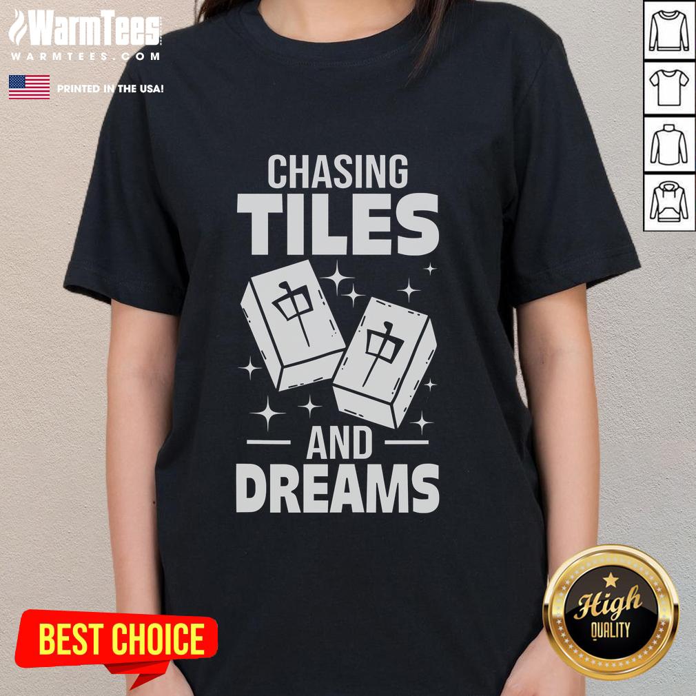 Asian player enjoying a game of Mahjong, wearing a stylish 'Chasing Tiles and Dreams' ladies tee, immersed in gameplay.