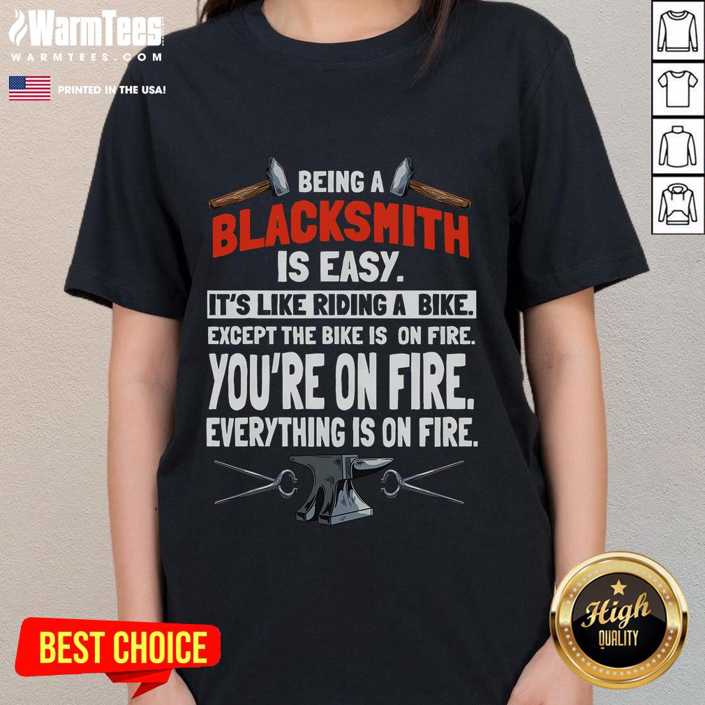 Alt Text: Funny blacksmith tee for ladies: 'Being a blacksmith is easy, like riding a bike, except everything is on fire.'