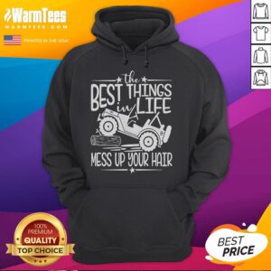 Person wearing a hoodie on a truck hood, laughing with messy hair, capturing the funny best things in life this summer.