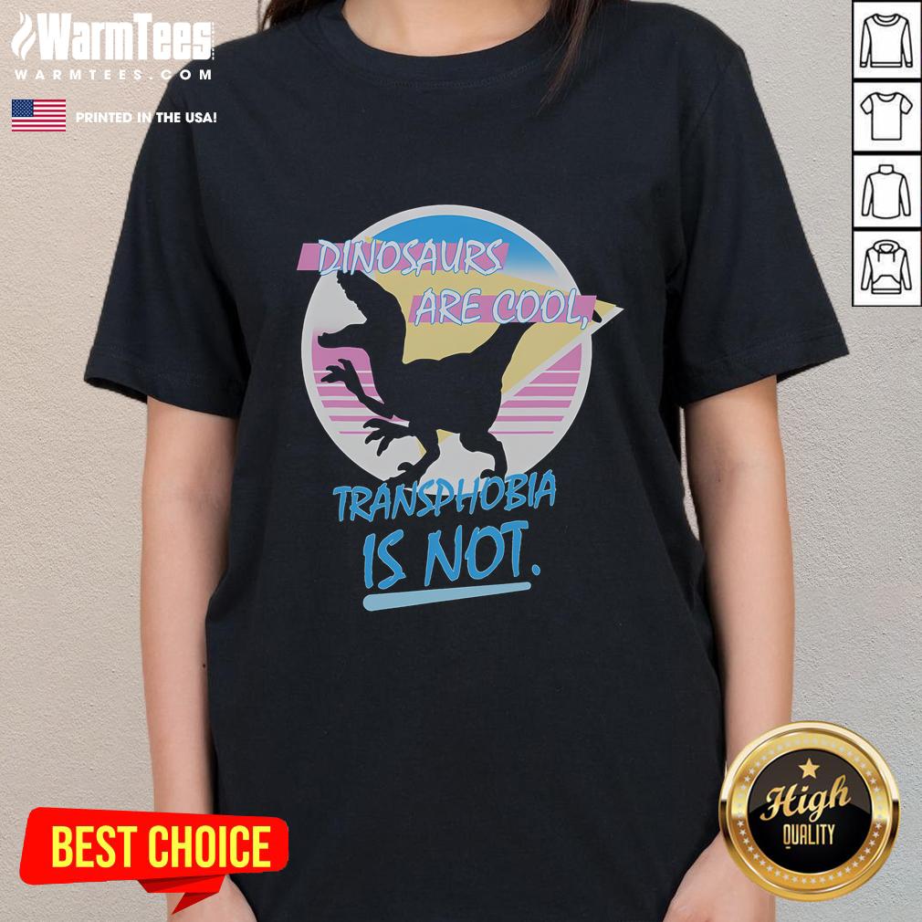 Funny dinosaurs graphic on a women's tee with text: 'Dinosaurs Are Cool, Transphobia Is Not' promoting inclusivity.
