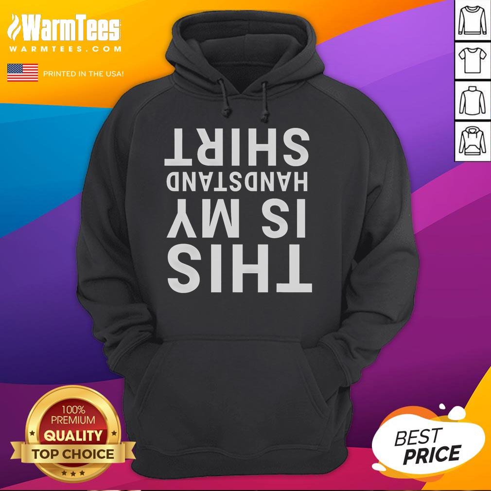 Person in a Funny This Is My Handstand hoodie doing acrobatics upside down in a gym setting.