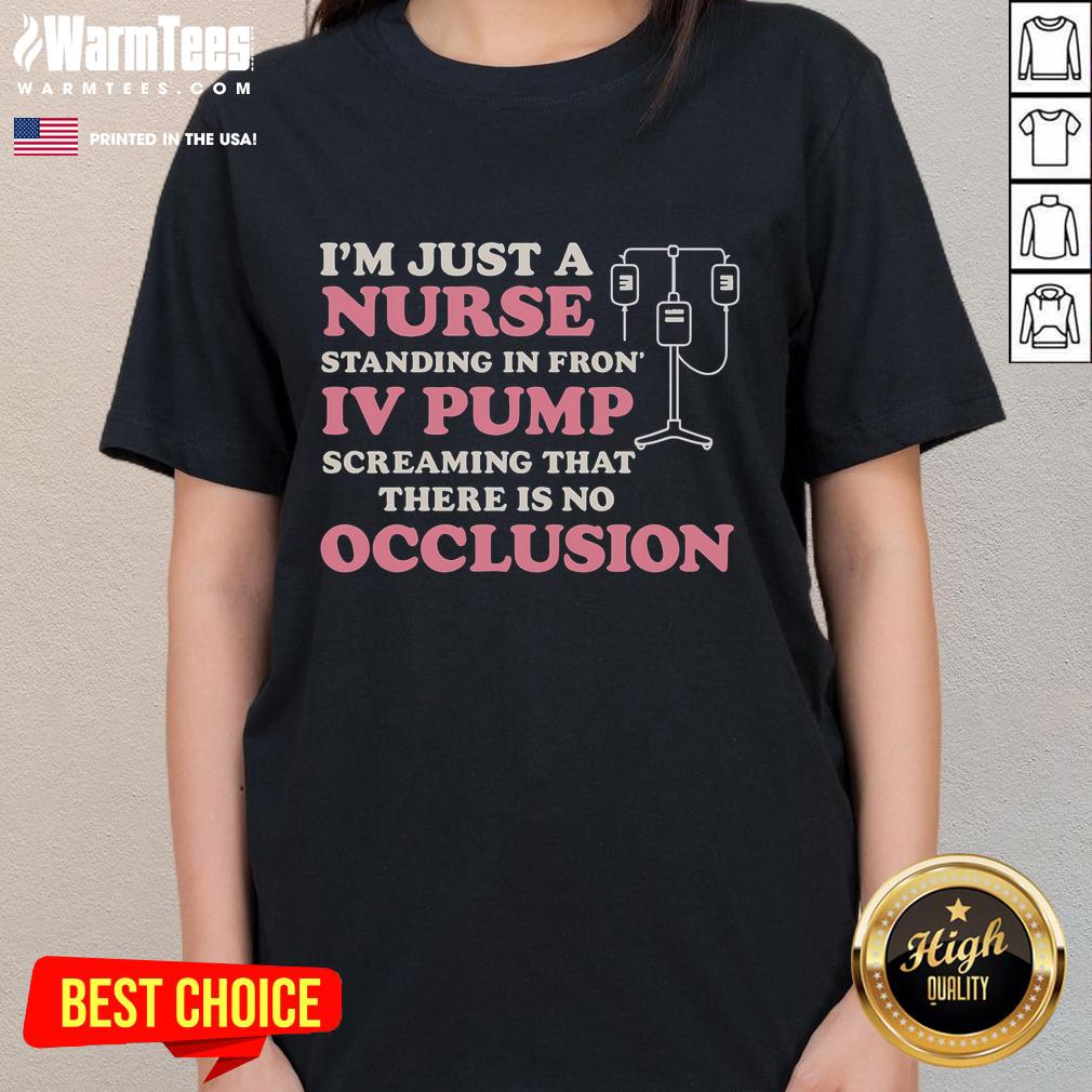 Nurse wearing a 'Good I'm Just A Nurse' tee stands confidently in front of an IV pump, showcasing dedication to healthcare.