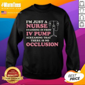Alt Text: Nurse wearing 'Good I'm Just A Nurse' sweatshirt standing in front of an IV pump in a hospital setting.