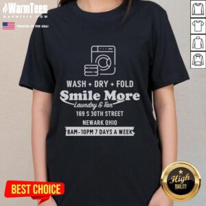 Alt Text: Happy Roman Atwood smiling in a Smile More laundry tee while folding clothes in Newark, Ohio.