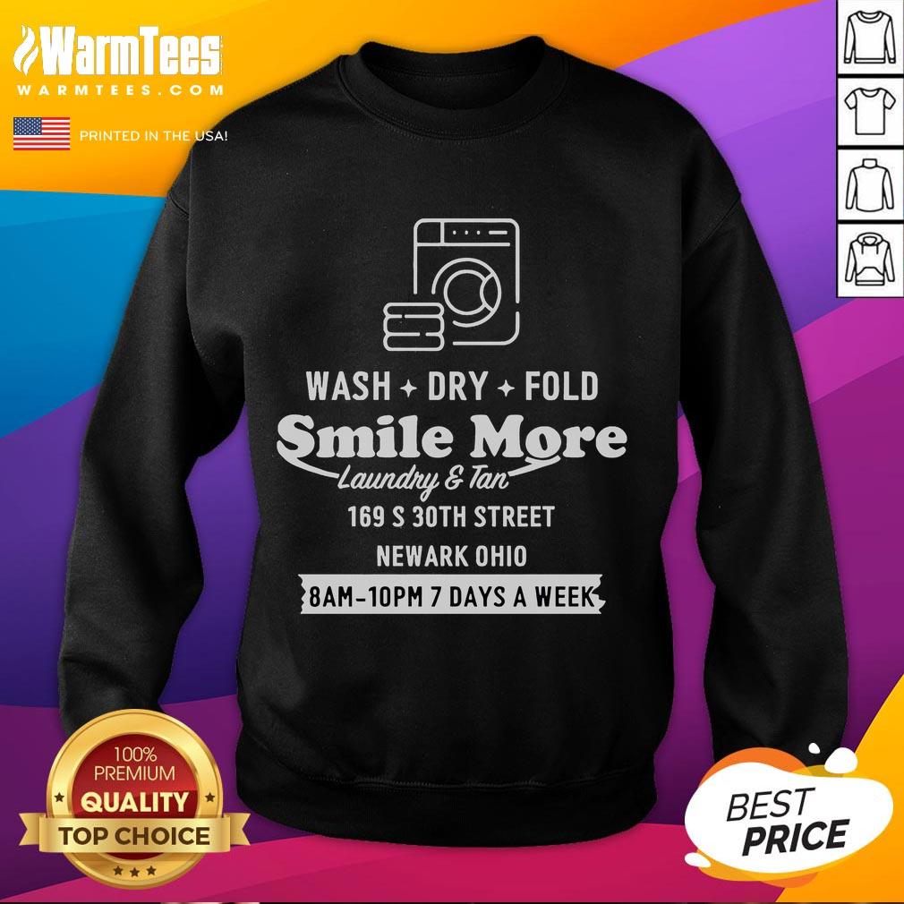 Happy Roman Atwood wearing a 'Smile More' sweatshirt while doing laundry in Newark, Ohio, showcasing his joyful personality.
