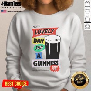 Cozy 'Good It's a Lovely Day for a Guinness' sweatshirt displayed on a wooden background, perfect for beer lovers.