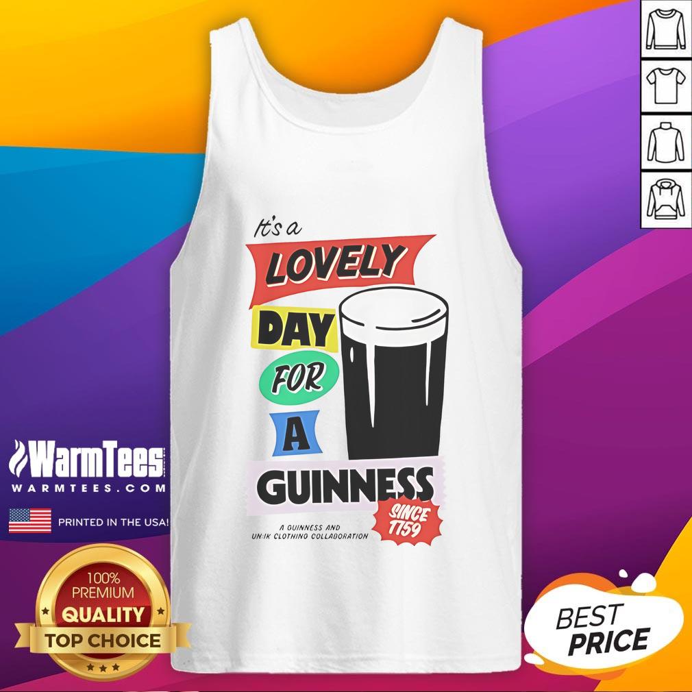 Person wearing a 'Good It's a Lovely Day for a Guinness' tank top outdoors, enjoying a sunny day.