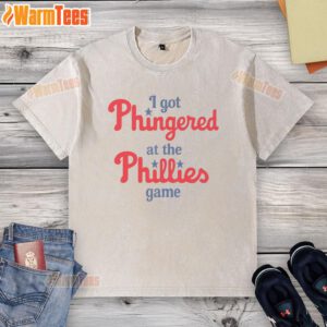 Alt Text: Funny 'I Got Phingered at the Phillies Game' washed t-shirt displayed on a wooden background.