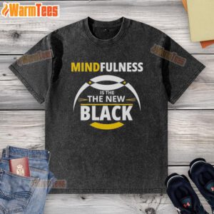 Top mindfulness is the new black washed t-shirt displayed on a hanger with a minimalist background.