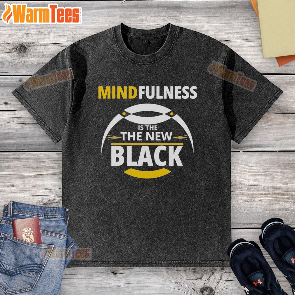 Top mindfulness is the new black washed t-shirt displayed on a hanger with a minimalist background.