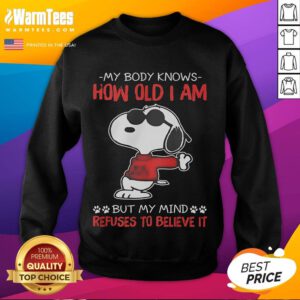 Funny Snoopy sweatshirt with 'My body knows how old I am but my mind refuses to believe it' design.