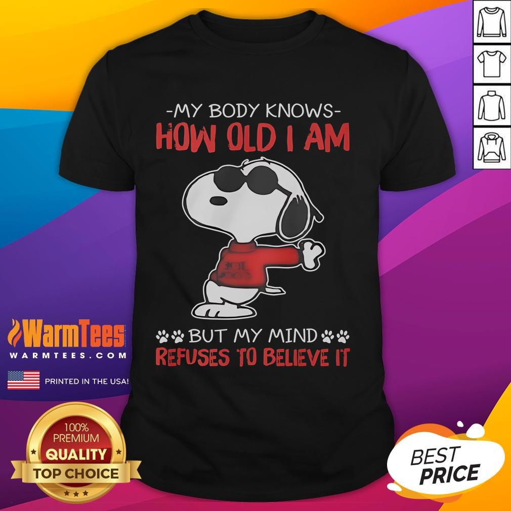 Alt Text: Funny Snoopy t-shirt featuring the phrase My Body Knows How Old I Am But My Mind Refuses To Believe It.