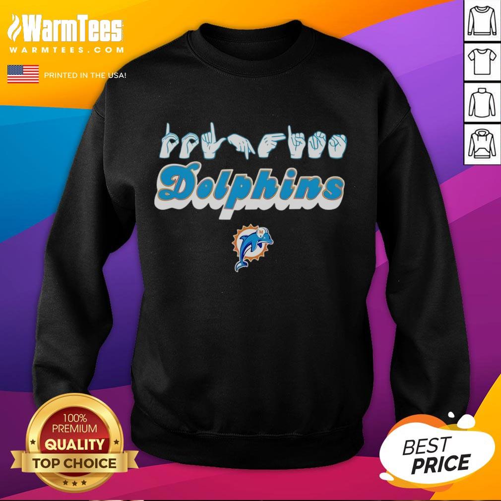 Youth in Miami Dolphins sweatshirt making love sign with hand signals, showcasing team spirit and style.