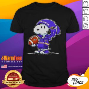 Alt Text: Snoopy in a hoodie smiling at fans on a Good Peanuts Baltimore Ravens T-shirt, showcasing team spirit and fun.