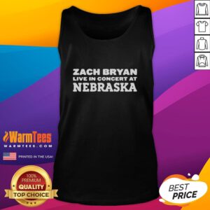 Zach Bryan performing live in Nebraska, wearing a stylish tank top at a vibrant concert event.