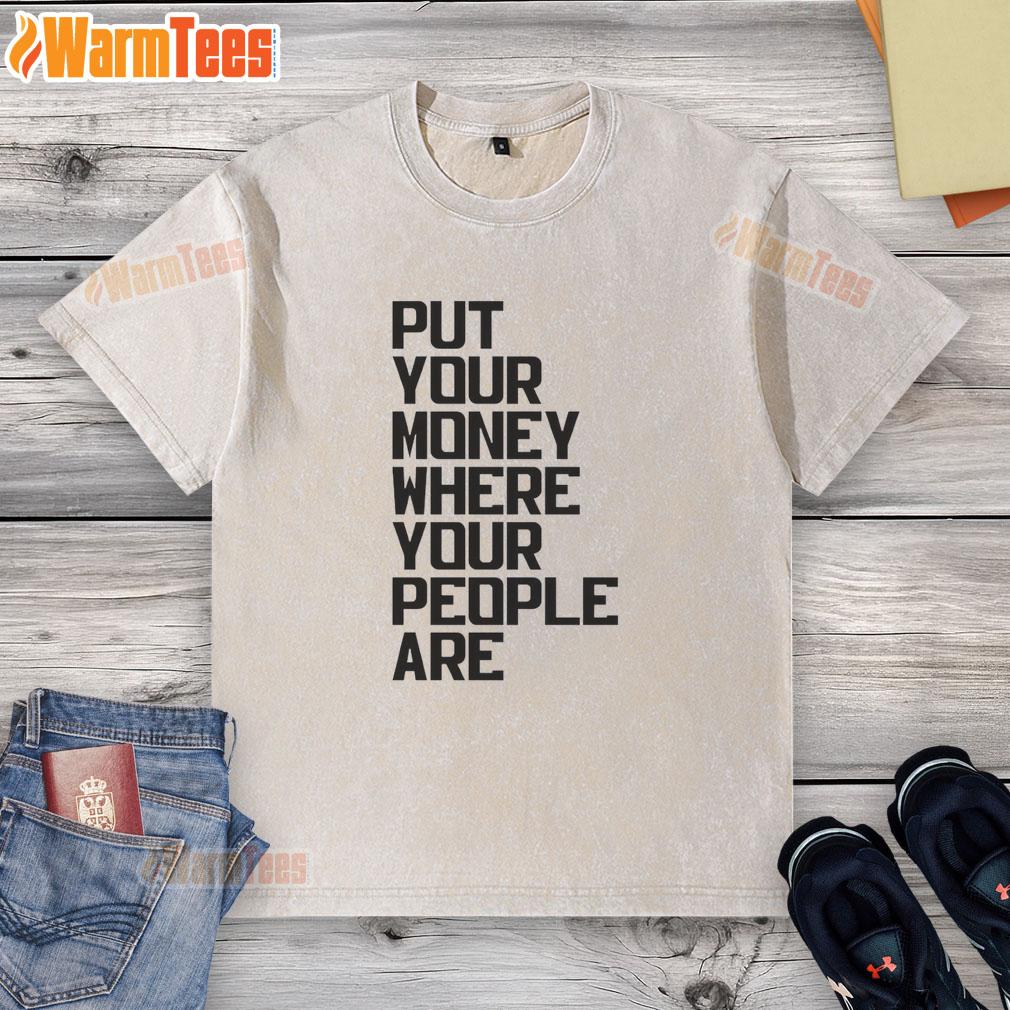 Pretty Put Your Money Where Your People Are washed t-shirt displayed on a wooden background, showcasing trendy design.